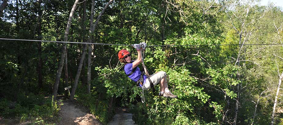 A woman on a zipline in the woods